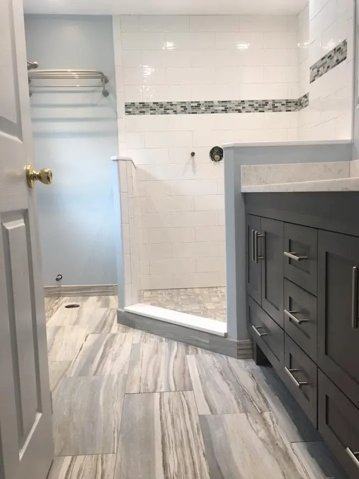 Renovated bathroom with a wood vanity and fully tiled shower