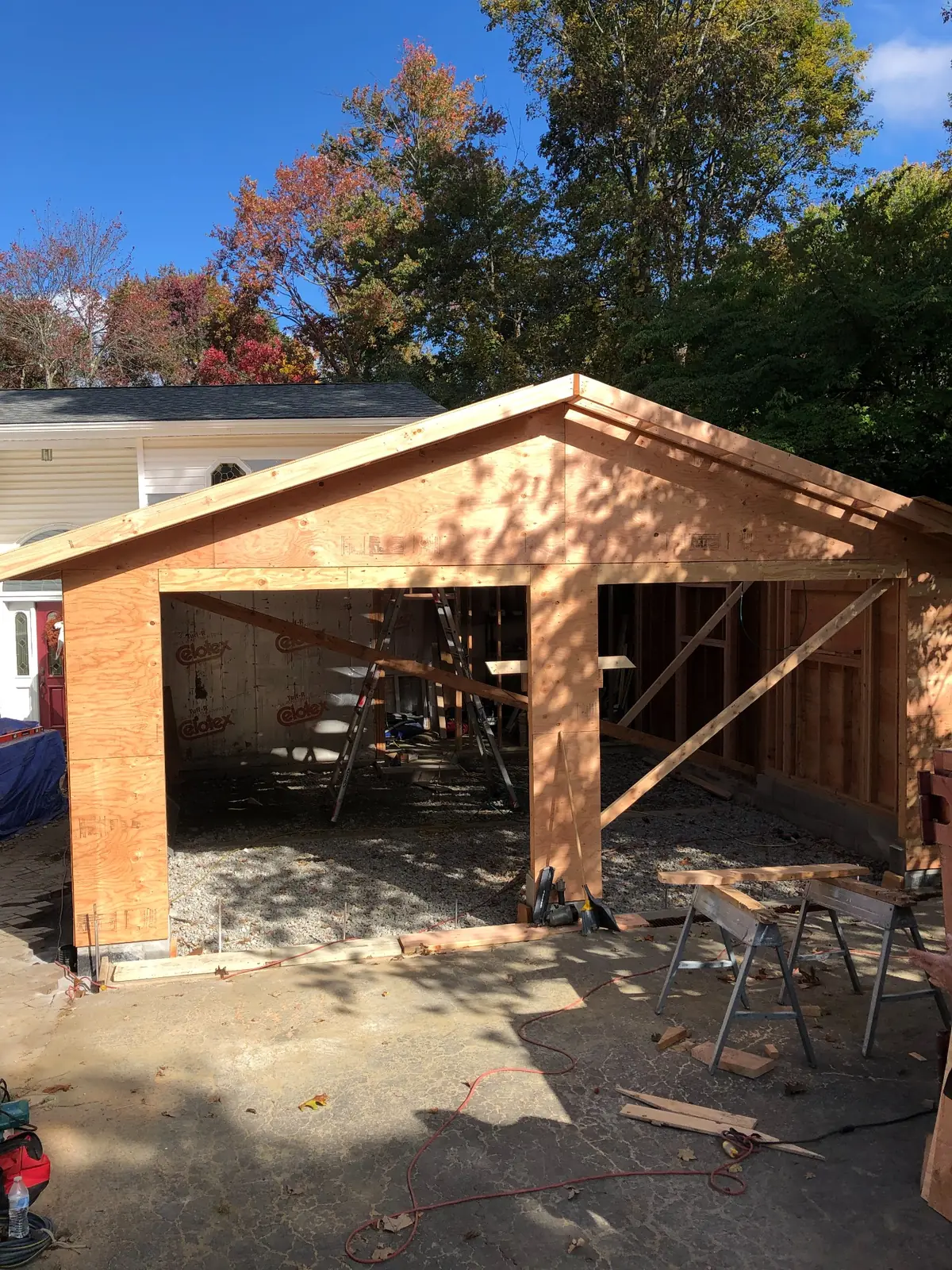 Garage addition framed and sheathed beneath a blue autumn sky in the Hudson Valley